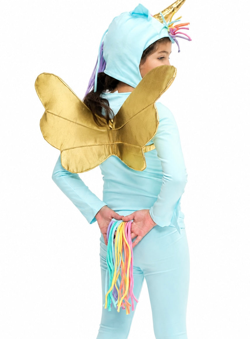 A child wearing a light blue unicorn costume with a gold horn, large gold wings, and multicolored tassels, shown against a plain white background.