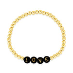 Name bracelet stacked with simple gold beaded bracelets on left model's wrist and heart bracelet with gold beads on right model's wrist