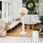 Outdoor living space with a white sofa, basketball hoop, and decorative elements.