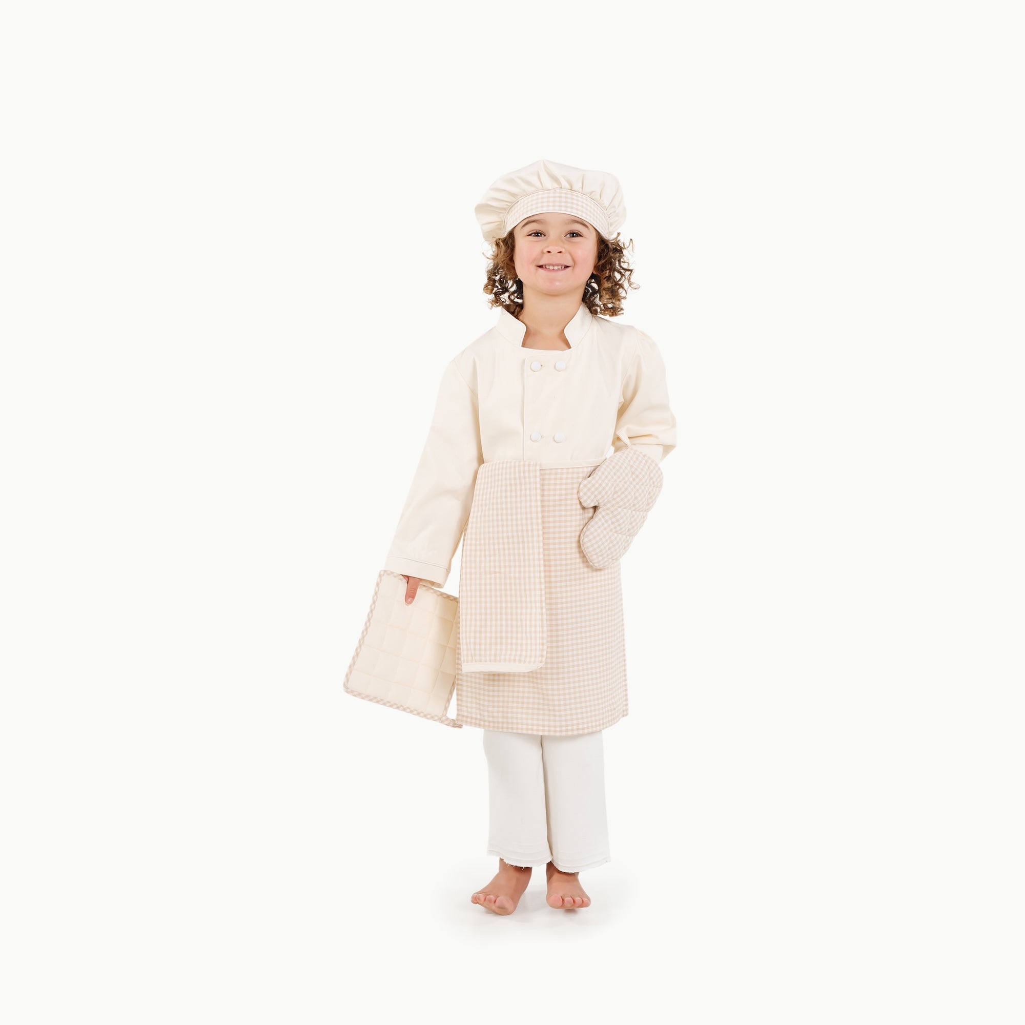Child wearing a cream-colored robe and nightcap on a white background