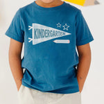 Child wearing a blue t-shirt with 'KINDERGARTEN' design on a white background