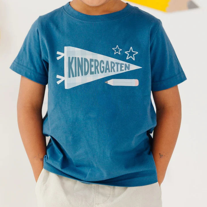 Child wearing a blue t-shirt with 'KINDERGARTEN' design on a white background
