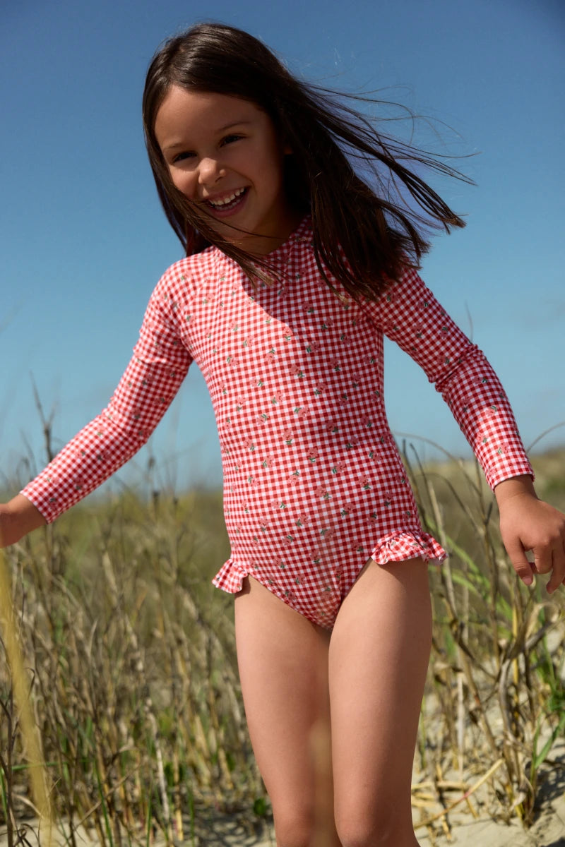 Girl wearing gingham swimsuit with flowers on it