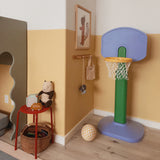 Children's playroom with a colorful basketball hoop, toys, and a teddy bear.