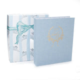 Light blue album with gold design and ribbon on a white background