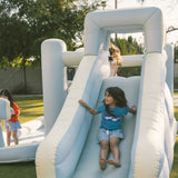 Children playing on an inflatable slide in a park