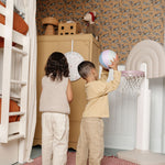 Two children playing with a basketball in a room.
